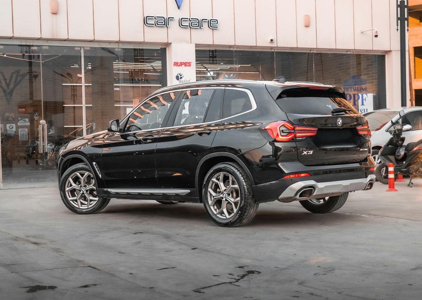 A sleek black BMW X3 parked at a modern car care center.